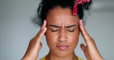 Stres ve baskı hisseden endişeli genç bir kadın. Siyah kız kafaya dokunuyor.