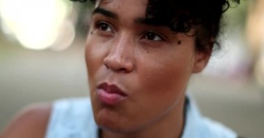 Candid black woman eating lunch alone. african person chewing food close-up face