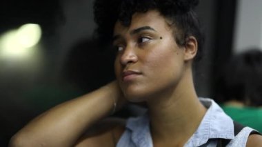 Yeraltı metrosunda gidip gelen genç siyahi kadın, trenin camından dışarı bakan kişi.