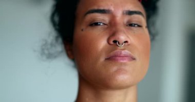 Ciddi Latin kökenli genç siyahi kadın portresi kameraya bakıyor. Karışık ırk insanı