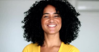 Kameraya gülümseyen mutlu genç melez kadın. Afro-Amerikan kadın gülüşü