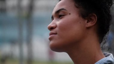Pensive young black woman looking at sky. Thoughtful African mixed race girl in contemplation
