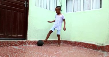 Little boy playing with ball. African ethnicity child plays soccer
