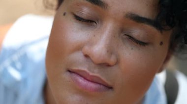 Happy young African woman opening eyes