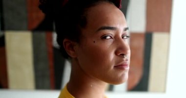 Genç Brezilyalı kadın kameraya bakıyor.