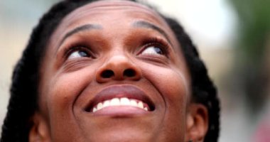Black African woman close-up face looking at sky feeling happy