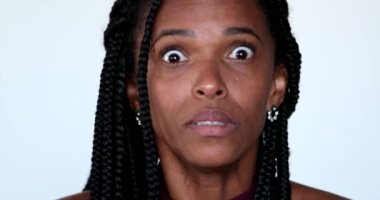 Exaggerated FUN black African woman reacting with SHOCK and terror to news, close-up portrait face reaction
