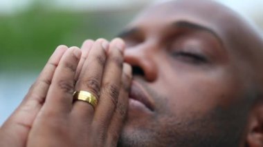 Spiritual black African man praying to God asking for help and guidance