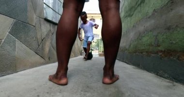 Afrikalı baba ve çocuk evdeki sokakta futbol oynuyorlar.