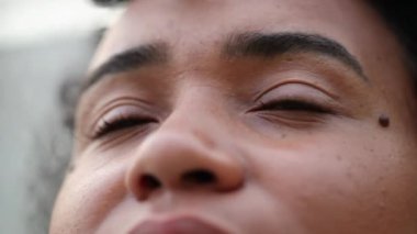 Young black woman face looking at camera, close-up eyes