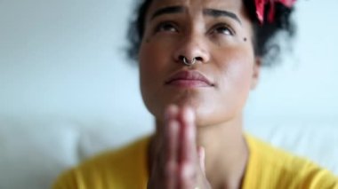 Thankful young black woman praying with hope and faith