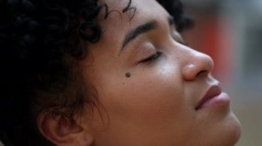 Woman closing and opening eyes in meditation outside feeling hopeful