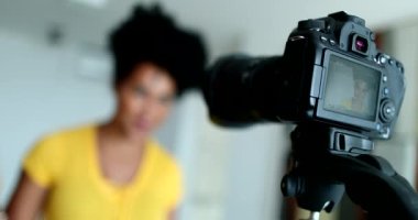 Female vlogger speaking at camera from home