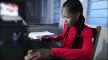 African adolescent girl studying writing notes at home