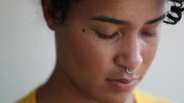 Pensive young black woman thinking. African mixed race girl looking down in contemplation