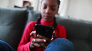 Teen black girl typing on smartphone. adolescent african girl holding cellphone