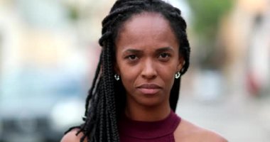 Portrait black African woman looking at camera. serious 40s mixed race lady standing outside