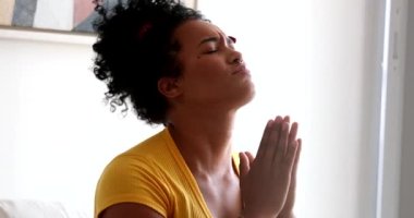 Evanjelik genç kadın evde dua ediyor.