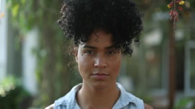 Portrait African American girl looking at camera with serious face. Young mixed race woman