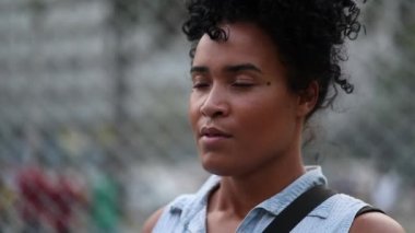 African woman taking a deep breath outdoors