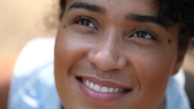 Happy young black woman looking at sky, close-up face african girl smiling
