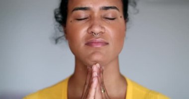 Genç siyah kadın tefekkür içinde dua ediyor.