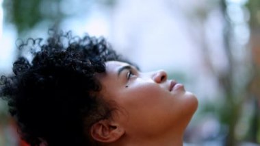 Young black woman looking up to sky with hope and faith