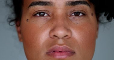 Young black woman macro close-up face looking at camera smiling