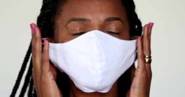 African woman taking off covid-19 face mask, end of outbreak concept