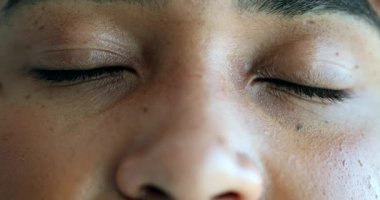 Siyahi biri meditasyonda gözlerini kapatıyor. Afrikalı kadın gülümsüyor.