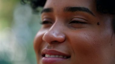 Happy young black woman looking at sky, close-up face african girl smiling