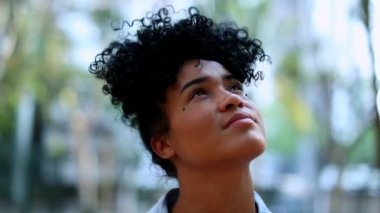 Young black woman looking up to sky with hope and faith