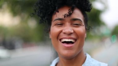 Young black woman smiling and laughing outside
