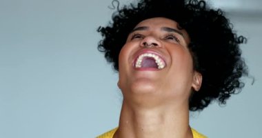 Genç siyahi kadın kahkahalarla gülüyor.