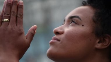 Black woman praying outside, african person looking up to sky worshipping