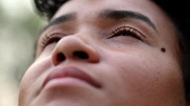 Black woman looking to sky in meditation. African woman closing eyes meditating