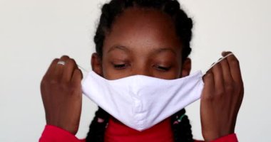 Child girl removing face mask feeling relief