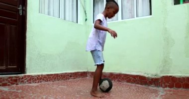 Little boy playing with ball. African ethnicity child plays soccer