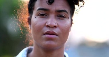 Young black woman taking a deep breath outside in contemplation. African Amercian girl smile portrait