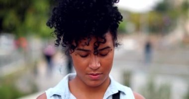 Portrait mixed race young woman standing outside looking at camera. Black African American girl
