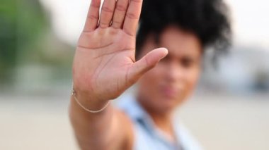 African woman making stop sign with hand, saying no against harassment