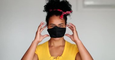 Mixed race young woman puts face mask prevention against virus outbreak