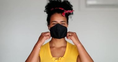 Mutlu genç siyahi kadın salgın maskesini çıkarıyor.