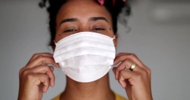 Siyah kadın covid-19 yüz maskesi çıkartıyor, salgın sona erdi.