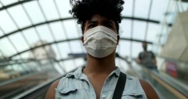 Yer altına giden banliyö kadını maske takıyor.