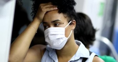 Tired black girl commuting to work riding subway, concerned african woman during pandemic
