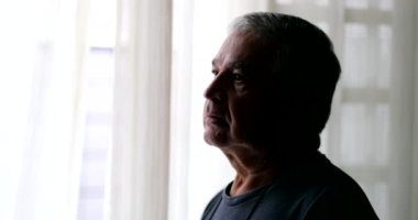 Pensive depressed older man profile in shadow