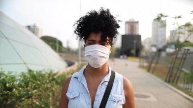 African american woman walking in city downtown wearing surgical mask