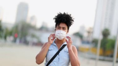 African woman removing covid-19 mask, end of pandemic. Black girl removes disease mask