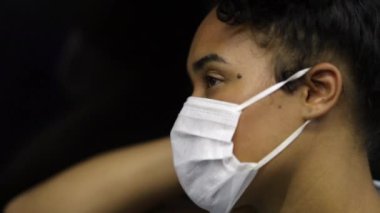 Exhausted african american woman commuting in subway wearing surgical mask. Tired commuter